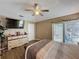 This is a well-lit main bedroom, complete with a dresser, tv, and access to the outdoor patio at 1364 Rebecca Dr, Haines City, FL 33844