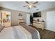 A lovely main bedroom with a large dresser, ceiling fan, and a view of the en suite bathroom at 1364 Rebecca Dr, Haines City, FL 33844