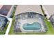 Aerial view of the backyard featuring a screened-in pool and a patio with outdoor furniture and well-maintained lawn at 1364 Rebecca Dr, Haines City, FL 33844
