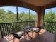 Balcony featuring two chairs and a table with a view of a lush green forest at 1375 Tuscana Ln # 1405, Davenport, FL 33896