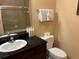 Bathroom featuring a dark countertop, dark-wood vanity, mirror, and tiled shower behind a glass door at 1375 Tuscana Ln # 1405, Davenport, FL 33896
