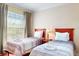 Comfortable bedroom with two twin beds, side table, and curtains, providing a relaxing space at 1375 Tuscana Ln # 1405, Davenport, FL 33896