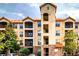 Exterior of the multi-story condominium building showing private balconies and manicured grounds at 1375 Tuscana Ln # 1405, Davenport, FL 33896