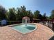 Kiddie pool with a water fountain, surrounded by a metal fence and brick walkway at 1375 Tuscana Ln # 1405, Davenport, FL 33896