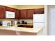 Efficient kitchen with wood cabinets, white appliances, and breakfast bar at 1375 Tuscana Ln # 1405, Davenport, FL 33896