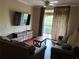 Comfortable living room area with a decorative wooden table, hardwood floors, and balcony access at 1375 Tuscana Ln # 1405, Davenport, FL 33896