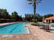Community pool with multiple lounge chairs, tables, and palm trees surrounding it at 1375 Tuscana Ln # 1405, Davenport, FL 33896
