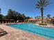 Large community pool featuring cabanas, lounge chairs, and mature landscaping at 1375 Tuscana Ln # 1405, Davenport, FL 33896