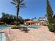 Community pool with a splash pad, palm trees, lounge chairs, and tables with chairs at 1375 Tuscana Ln # 1405, Davenport, FL 33896