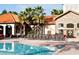 Resort style pool and clubhouse with lounge chairs, umbrellas, and meticulously maintained grounds at 1375 Tuscana Ln # 1405, Davenport, FL 33896