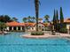 Community pool view of clubhouse, mature trees, and ample seating at 1375 Tuscana Ln # 1405, Davenport, FL 33896