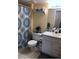 Bathroom featuring white vanity, decorative shelf, and a shower with patterned curtain, offering a relaxing space at 13838 Fairway Island Dr # 1418, Orlando, FL 32837