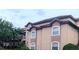 Exterior of condo building with tan siding, white trim and a red tile roof at 13838 Fairway Island Dr # 1418, Orlando, FL 32837