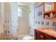 Cozy bathroom with a shower over tub, tiled walls, decorative accents, and a vanity sink at 1640 Marks St, Kissimmee, FL 34746