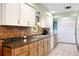 Functional kitchen featuring brick backsplash, wood cabinets, and stainless steel sink at 1640 Marks St, Kissimmee, FL 34746