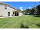 A view of the rear exterior of the home, showing the grassy backyard at 1843 Harbor Blvd, Kissimmee, FL 34744