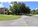 A view of the exterior of the home with mature trees, and a circular driveway at 1843 Harbor Blvd, Kissimmee, FL 34744