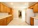 Kitchen with wood cabinetry, neutral countertop, white appliances, and tile flooring, offering a practical cooking area at 1843 Harbor Blvd, Kissimmee, FL 34744