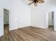 Bedroom features wood-look flooring, ceiling fan, and 6-panel door at 1851 Hammock Moss Dr, Orlando, FL 32820