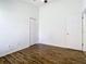 A simple bedroom featuring wood flooring, a ceiling fan, closet and a doorway at 1851 Hammock Moss Dr, Orlando, FL 32820