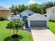 Charming single-Gathering home with palm trees, a gray roof and a two car garage at 1851 Hammock Moss Dr, Orlando, FL 32820
