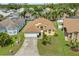 Aerial view of a yellow home with a brown roof, surrounded by lush landscaping and neighboring houses at 1914 Ellery Ln, Kissimmee, FL 34746