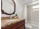 Bathroom featuring granite countertop, decorative mirror, and shower-tub combo at 1914 Ellery Ln, Kissimmee, FL 34746