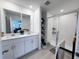 Bright bathroom with double sinks, a large shower with glass doors, and tiled floors at 2086 Crape Jasmine Ln, Orlando, FL 32824