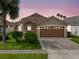 Charming single-Gathering home with a well-manicured lawn, lush landscaping, and a two-car garage at 2912 Lazlo Ln, Orlando, FL 32837