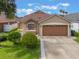 Inviting home featuring a manicured lawn, a two-car garage, and a well-maintained yard at 2912 Lazlo Ln, Orlando, FL 32837