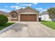 Inviting home showcasing a spacious driveway, a large garage, and neat landscaping at 2912 Lazlo Ln, Orlando, FL 32837