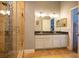 Bathroom featuring a tiled shower, a double sink vanity, and contemporary lighting at 3030 Eagle Crossing Dr, Kissimmee, FL 34746