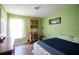 Cozy bedroom featuring a bright green wall, a window, and hardwood floors at 3030 Eagle Crossing Dr, Kissimmee, FL 34746