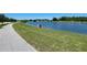 Scenic walking path with picturesque views of the pond with lush green space at 3030 Eagle Crossing Dr, Kissimmee, FL 34746