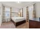 Cozy bedroom with plush carpet, white bedding, decorative curtains, and bedside table at 340 Pendant Ct, Kissimmee, FL 34747
