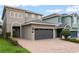 Beautiful home with a brick driveway, two-car garage, and manicured bushes at 340 Pendant Ct, Kissimmee, FL 34747