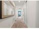 Hallway adorned with a decorative mirror and white walls, offering a view of a bedroom with a blue accent wall at 340 Pendant Ct, Kissimmee, FL 34747