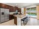 Bright kitchen with stainless steel refrigerator and island with granite countertops, adjacent to the pool area at 340 Pendant Ct, Kissimmee, FL 34747