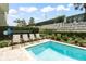 In-ground pool with lounge chairs and a privacy fence surrounded by trees at 340 Pendant Ct, Kissimmee, FL 34747