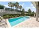 The in-ground pool is surrounded by brick pavers, a privacy hedge, and green foliage at 340 Pendant Ct, Kissimmee, FL 34747