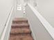 Carpeted staircase featuring a white banister and neutral colored walls at 340 Pendant Ct, Kissimmee, FL 34747
