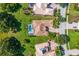 Aerial view of home with screened pool, green landscaping, and tile roof at 3427 Harborside Ct, Kissimmee, FL 34746