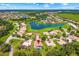 Aerial view of a residential neighborhood featuring a lake, lush greenery, and well-maintained homes at 3427 Harborside Ct, Kissimmee, FL 34746