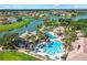 Aerial view of a community pool and clubhouse area with palm trees and beautiful lakeside homes at 3427 Harborside Ct, Kissimmee, FL 34746