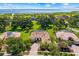 Aerial view of a house with a brown tile roof surrounded by lush greenery and a nearby lake at 3427 Harborside Ct, Kissimmee, FL 34746