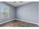 Bedroom featuring wood-look tile floors, large window, and light blue walls, and ample natural light at 3427 Harborside Ct, Kissimmee, FL 34746