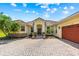 Beautiful single-story home with a brick driveway, well-manicured landscaping, and a tile roof at 3427 Harborside Ct, Kissimmee, FL 34746