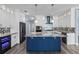 Gourmet kitchen boasts a blue kitchen island, stainless steel appliances, and elegant lighting at 3427 Harborside Ct, Kissimmee, FL 34746