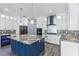 Stunning kitchen with white cabinets, blue island, stone countertops, and modern backsplash at 3427 Harborside Ct, Kissimmee, FL 34746