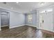 Bright living room with hardwood floors, large window, and a white front door with sidelights at 3427 Harborside Ct, Kissimmee, FL 34746